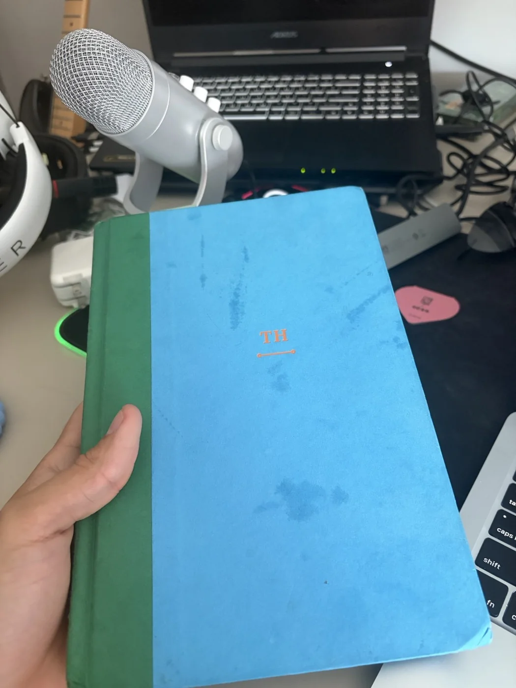 A blue hardcover book held at Renilson’s desk